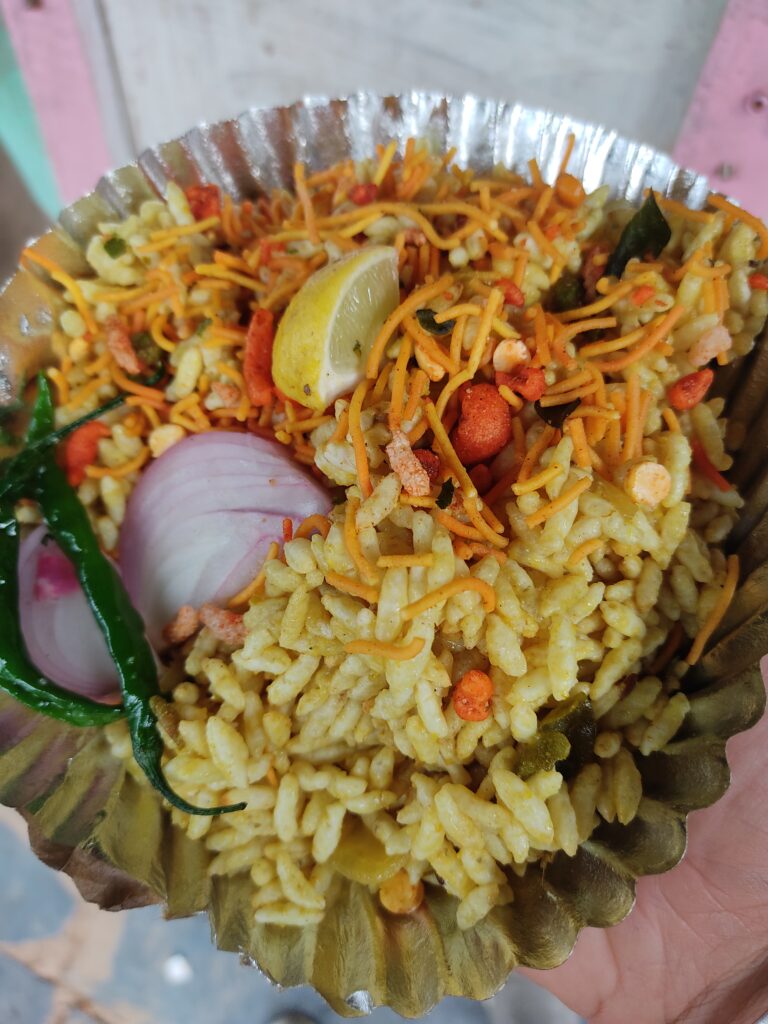 A picture of the mandakki snack which consists of Puffed rice with onions, green chillies, sev, roasted pulses that are tossed together for maximum flavour.